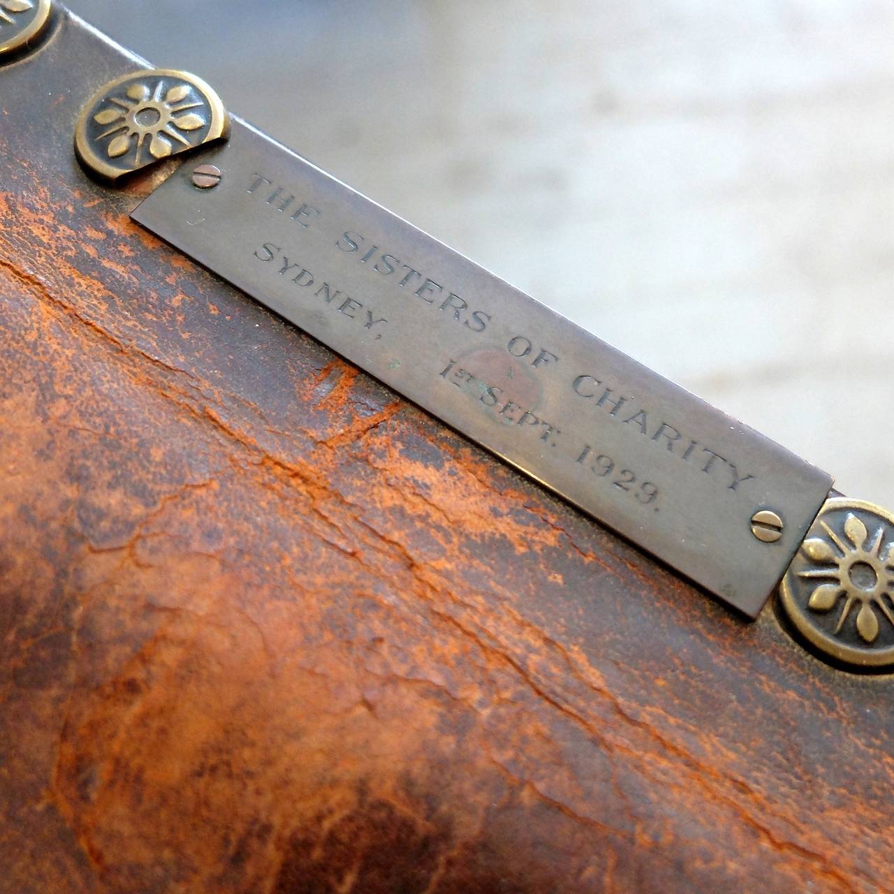 Early 20th century, with horsehair stuffing, an oak frame and bun feet. Embossed brass studs throughout, and attached is a brass plaque engraved 'The Sisters of Charity, Sydney 1929'