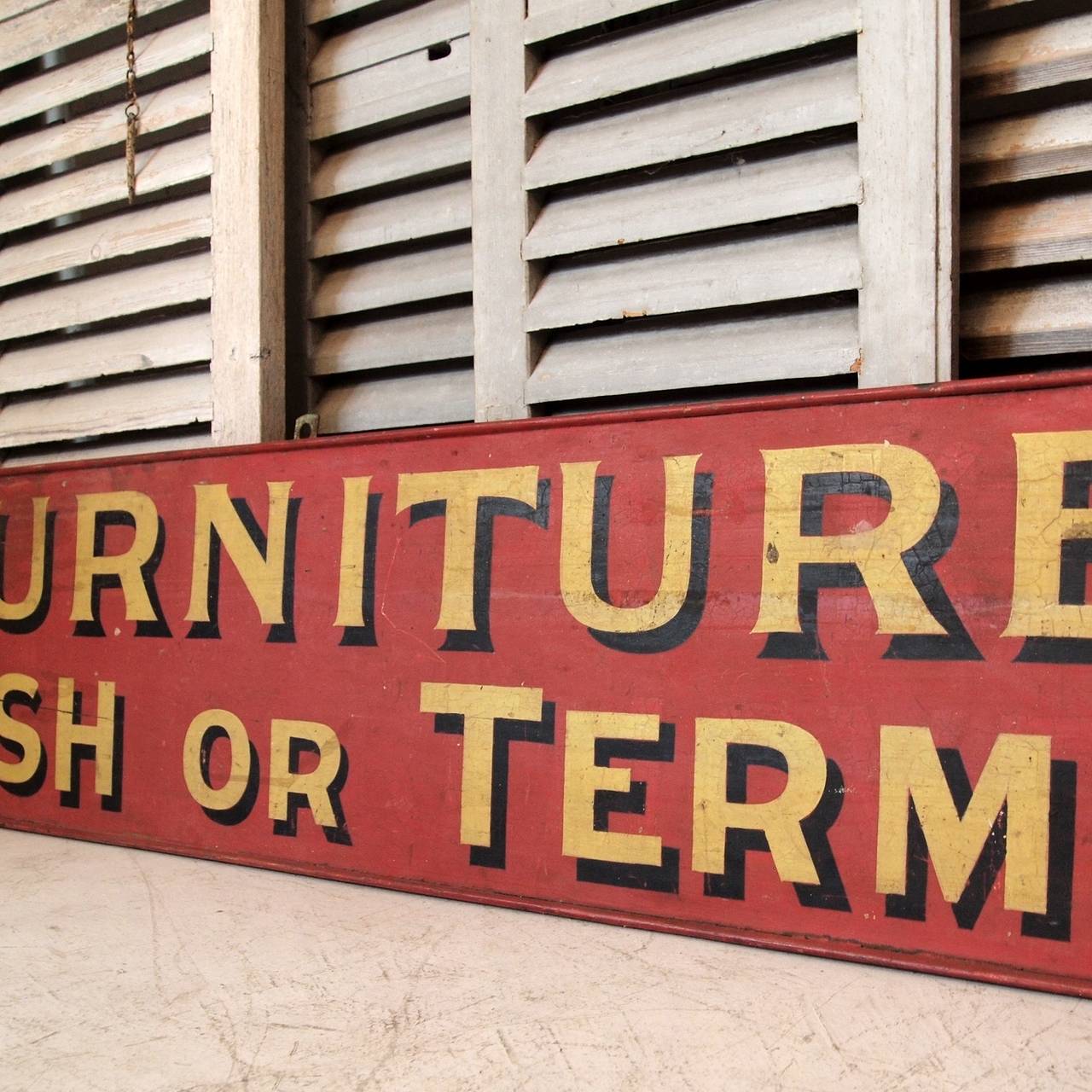 Both sides of the sign read the same 'FURNITURE - CASH OR TERMS' in hand-painted shadowed lettering.