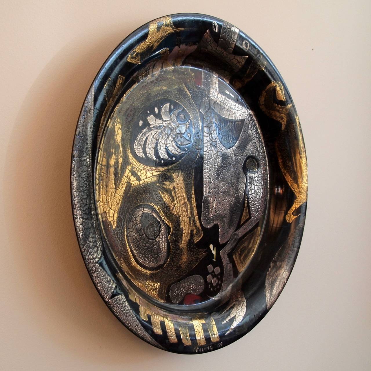 Steel platter with vitreous enamel decoration, showing two faces. Silver and gold on a navy ground. Signed and dated 1969. 

Hesling was a British born artist who settled in Australia and had a varied and interesting career a bit of a tearaway as