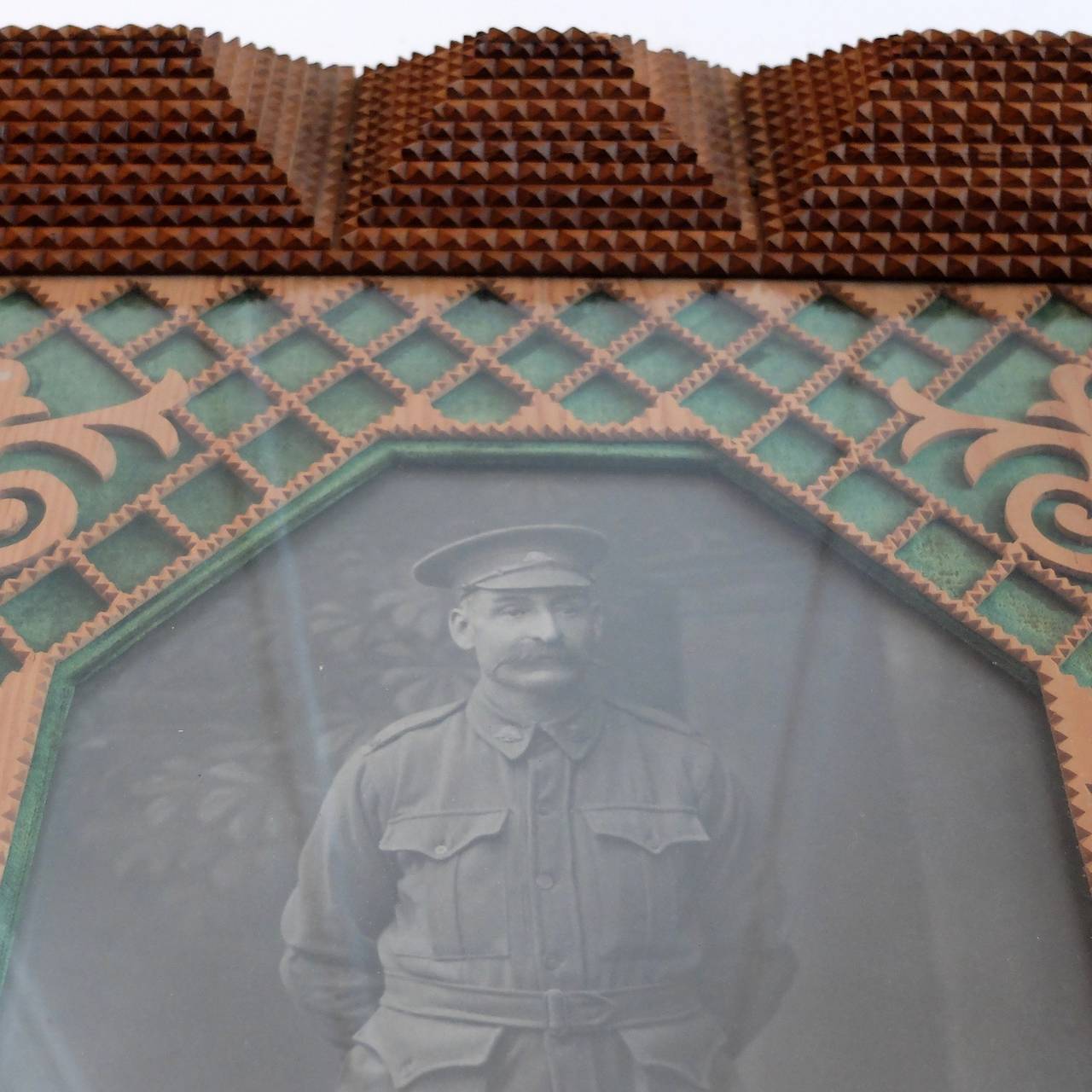 Large tramp art frame, with WW1 portrait of Australian soldier 'Al More' in a fretwork surround with green velvet backing.