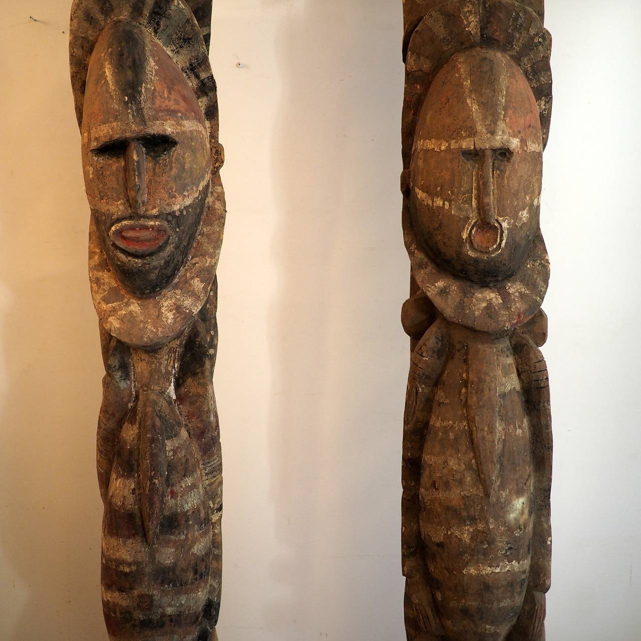 Two large figurative house posts, male and female. Made by the Abelam people, from the Maprik area of Papua New Guinea, in the Prince Alexander Mountains. carved wood with natural pigments, each mounted on a heavy steel stand. Female figure 235cm