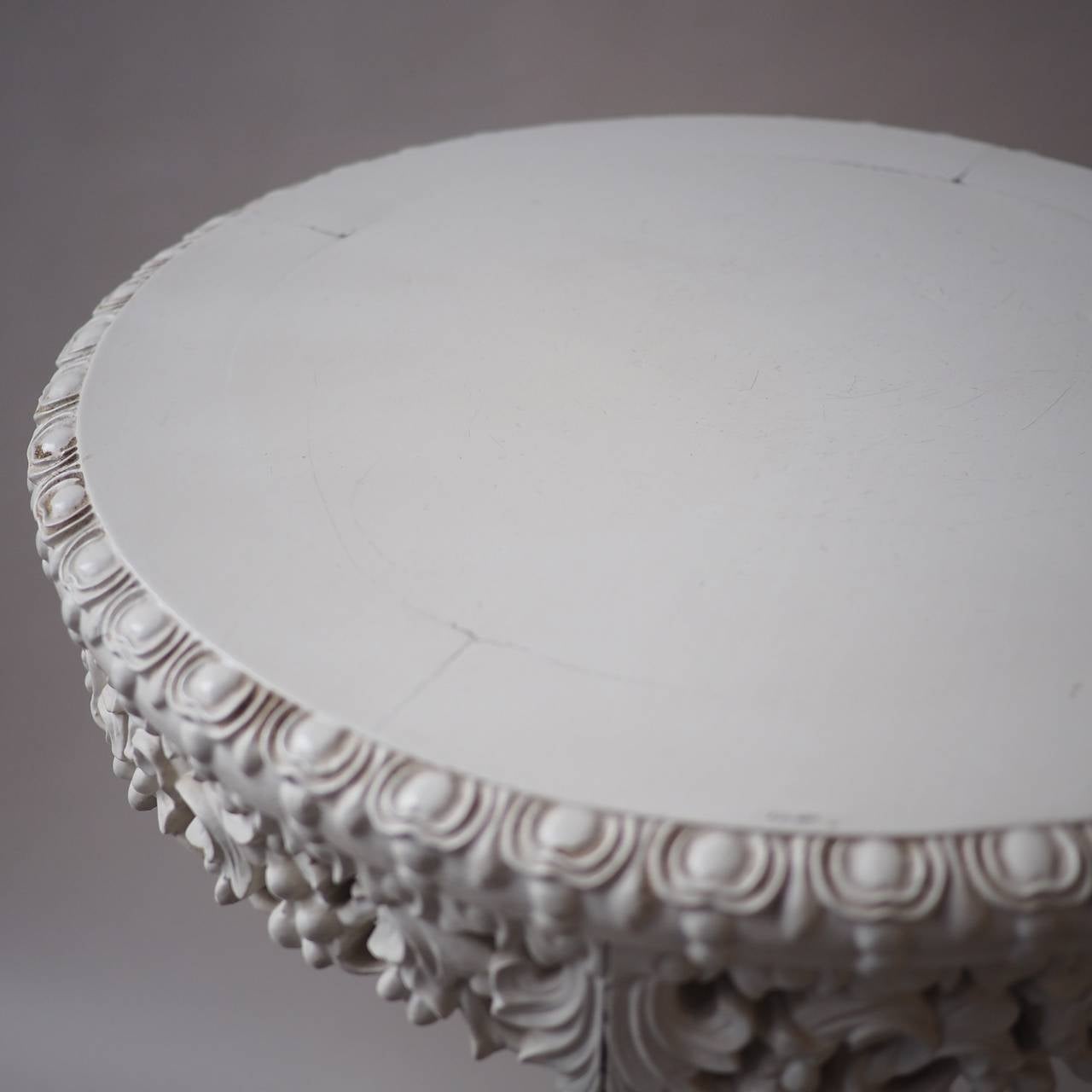 Small circular white painted timber tripod table, the circular top with carved and pierced apron, on a dragon carved support and ball and claw feet.