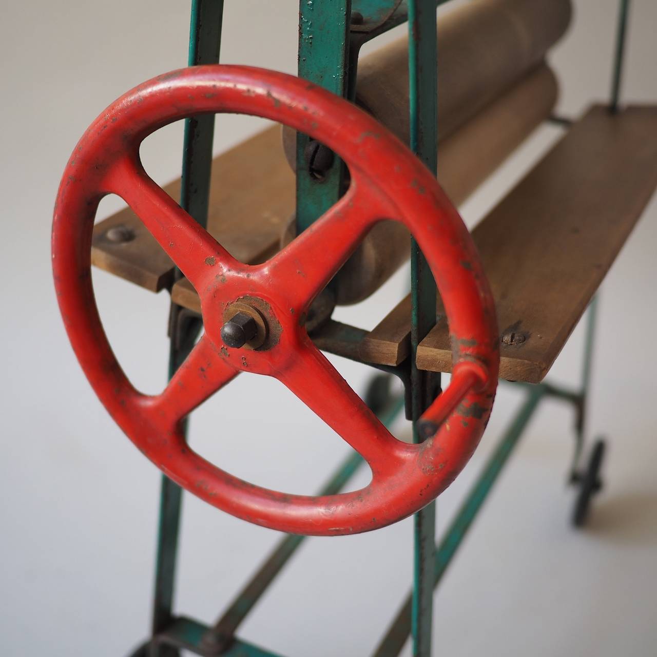 painted steel frame, timber rollers and rubber-rimmed wheels