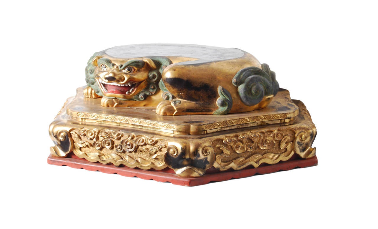Rare and unusual hexagonal Buddhist base for a statue with a recumbent shi-shi (guardian lion dog), gilded and carved with inset glass eyes and painted with mineral pigments. 
Most likely the base to a sculpture of Monju Bosatsu, a Buddhist deity