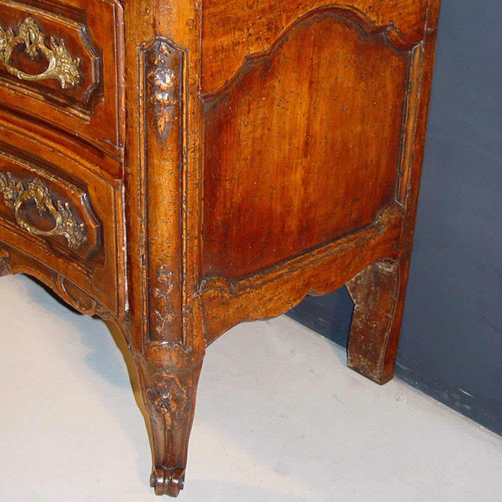 Louis XV period walnut commode. The serpentine fronted saint beat marble top with moulded edge above two carved long drawers with bronze handles and key escutcheons and on cabriole legs with scrolled toes, circa 1765.
