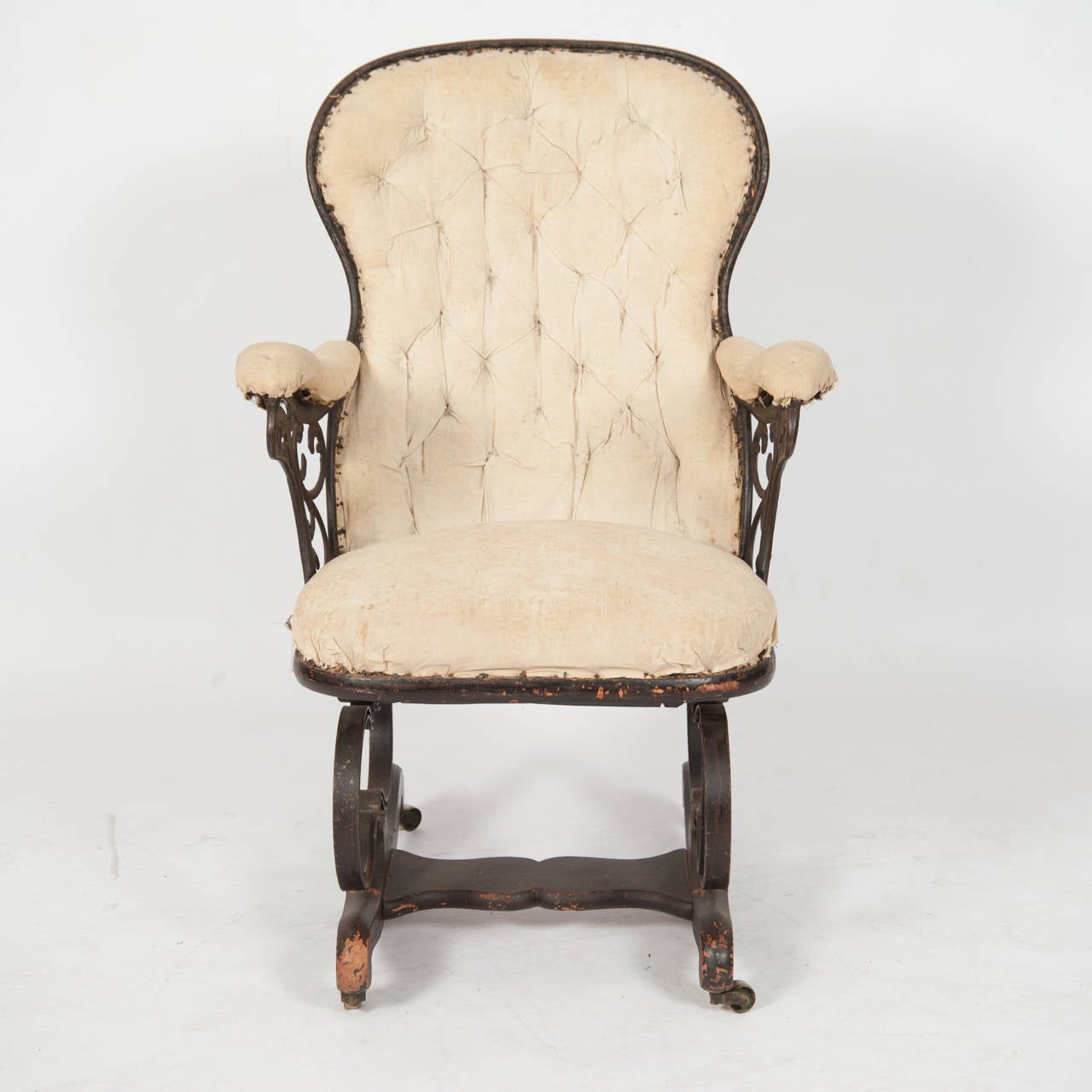 American Rocking Chair The Metal Frame With A Buttoned Spoon Back Padded Arms Above Cast Scroll Work The Sprung Chasse on Timber Feet and Casters

Height 940 
Length 620 
Depth 620