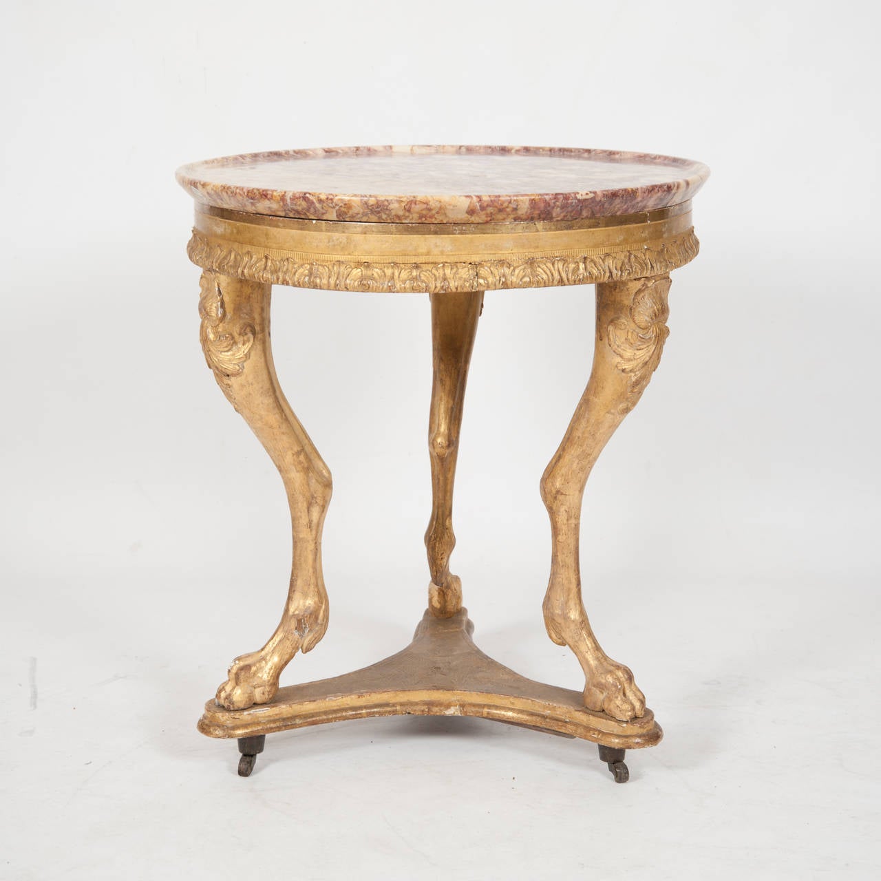 French Empire circa 1810 Gueridon The Turned Marble Top On A Cylindrical Rail Carved Acanthus Detail Supported On Three Naturalistic Lion Legs Joined By A Trifoil Base On Casters With Original Gilt