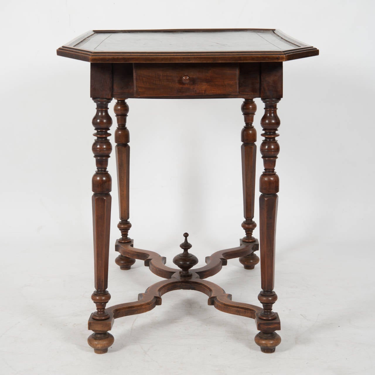 Superbly Patinated French Walnut Side Table circa 1800 Tooled Leather Top With A Moulded Edge Raised On Turned Chamfered Pillars Joined By A Wavy X Stretcher On Bun Feet With Central Finial