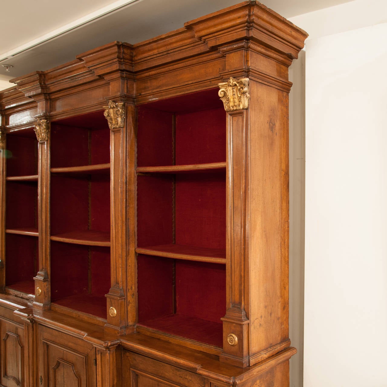 Italian Walnut Breakfront Bookcase C1860 The Deeply Moulded Cornice Above Columns With Gilded Capitols And Roundels Above Three Paneled Doors On Bracket Feet circa 1850 

Height 2430 
Length 2740 
Depth 530