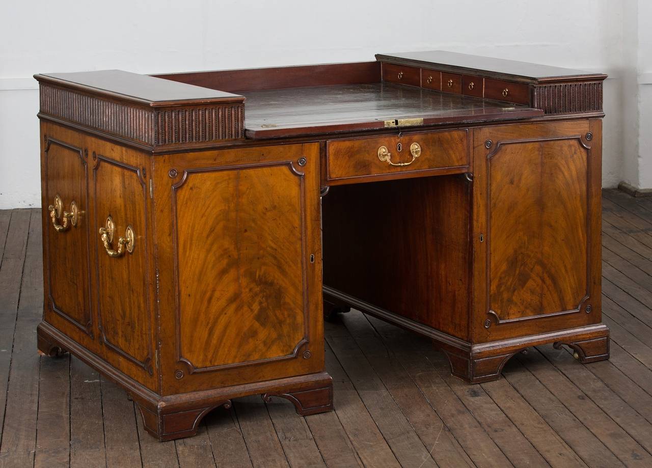 The Felton bequest George III mahogany enclosed pedestal Desk, the moulded rectangular top centered with a sliding green tooled leather writing surface, opening to reveal a fixed leather writing surface flanked by two sets of five drawers each with