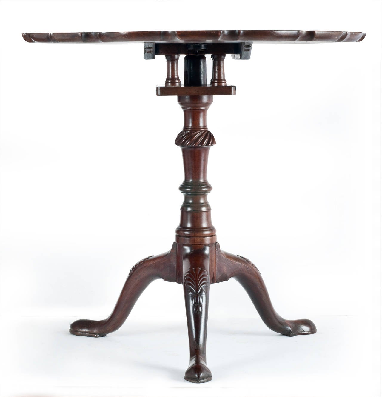 George III English mahogany pie-crust edged tilt top, bird-cage base wine table

The well patinated pie-crust moulded single plank top, above a bird-cage revolving tilt-top base. Resting on a well turned and carved centre support, resting on