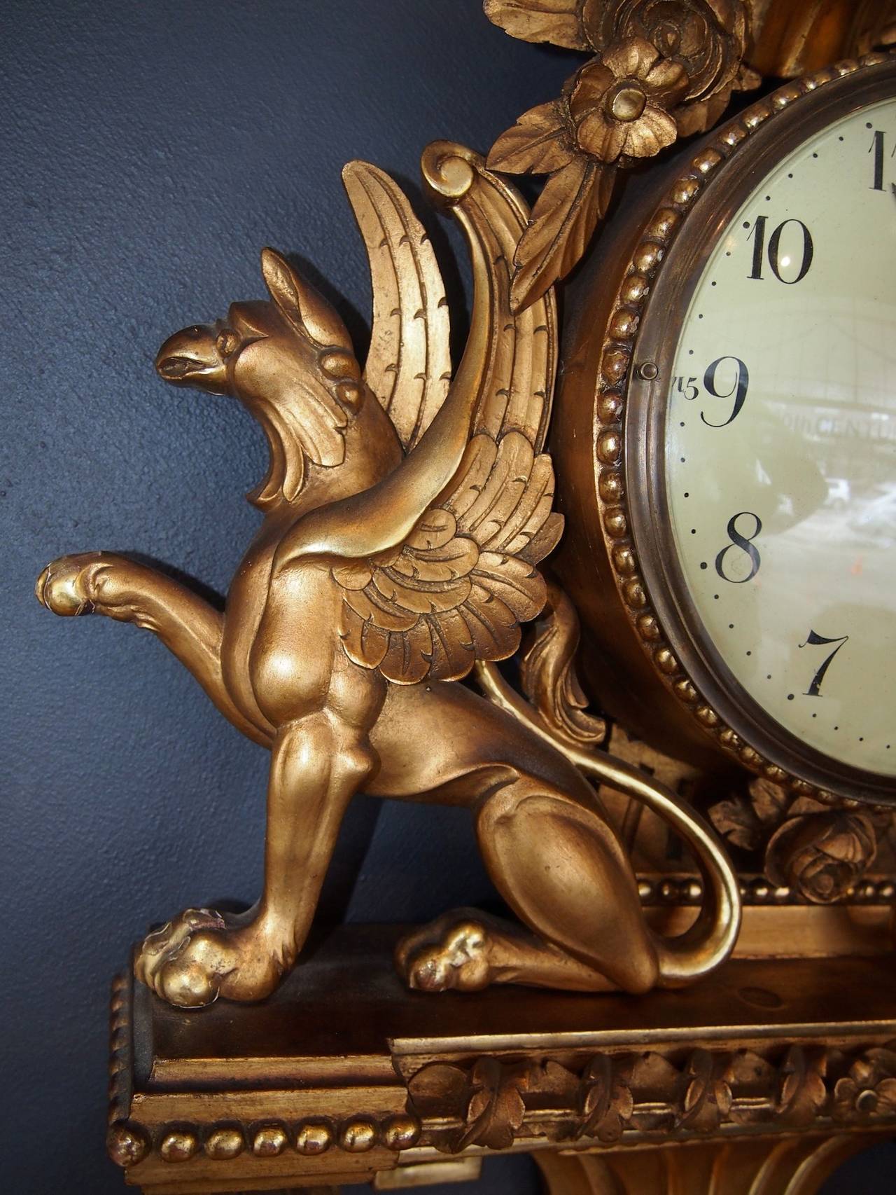 Carved giltwood Cartel clock with classical detailing. Original hand drawn dome glass.