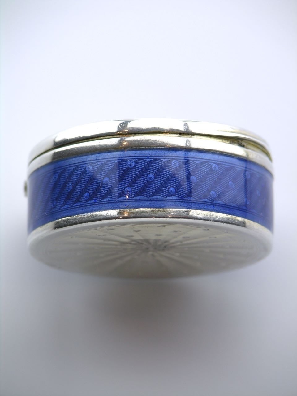A larger hinged lidded box with a blue checker board guilloche pattern to the lid and a diagonal rope and dot pattern to the sides. The base has a radiating dot pattern - numerous numerical marks - total weight 54.6grms