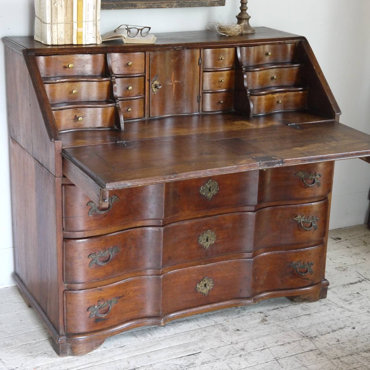 19th century French oak secretaire with three large serpentine drawers and a fitted interior containing six graduated drawers, six petite drawers and a small central cabinet all with rich color and patination and original hardware. Great storage and