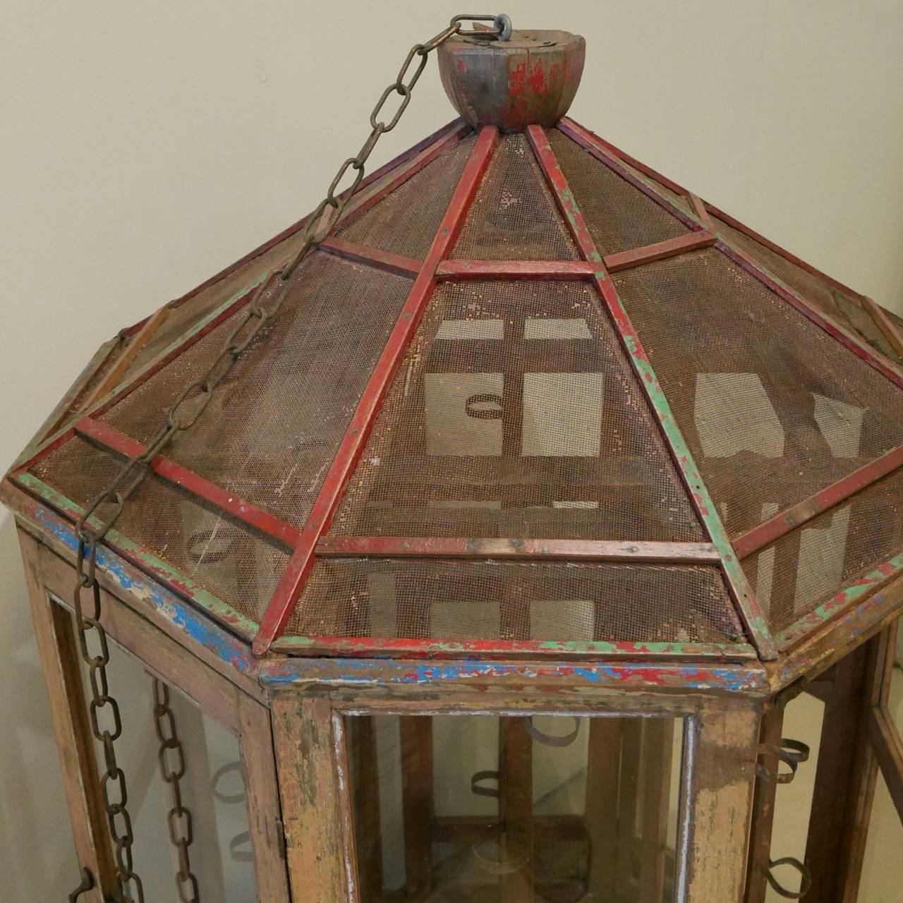 A painted vintage Indian prayer cabinet that was used in temples. This unusual piece can hold 48 candles - there are eight wooden posts that hold six tea light candles on each post, accessible by four of the glazed doors.