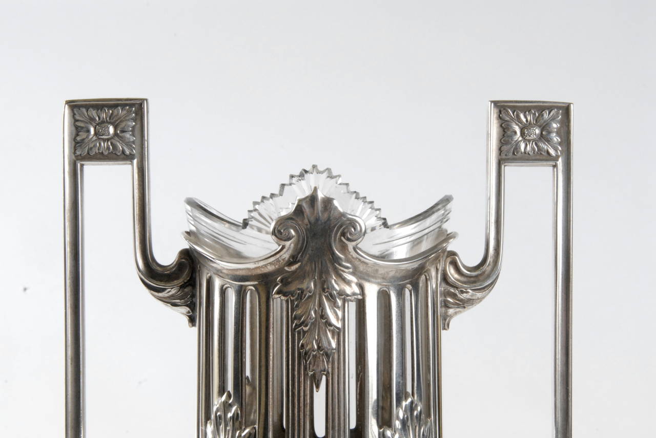 A WMF [Wurttembergische Metallwarenfabrik] Secessionist period silver plated vase with its original liner, circa 1906. Supported on four paw feet connected by laurel swags and finishing with laurel leaves.
A pierced cylindrical neck is surmounted