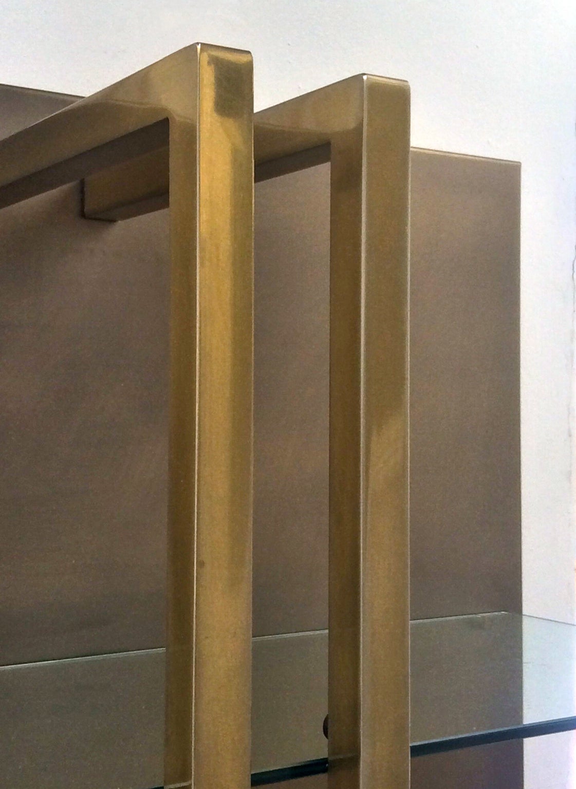 Shelving unit or étagère attributed to Belgo Chrome, Belgium, 1970s.

A stylish freestanding piece in good original condition, comprising a bronze patinated steel-faced board with five glass shelves and brass plated details. The facing covers