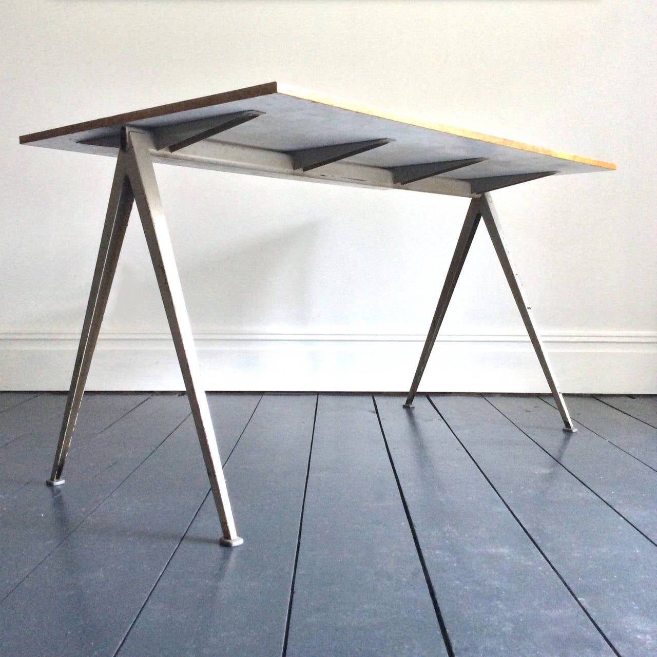 Rare Pyramid table with grey folded metal frame, designed by Wim Rietveld for Ahrend de Cirkel.  The design of the table - inspired by the Compass table of Jean Prouvé - received the Signe d'Or award in 1960.

This piece has wear to the frame in