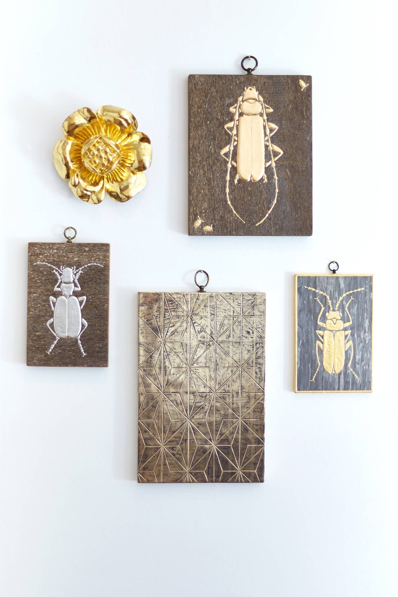 A collection of five panels decorated using a mixture of different gilding and gesso techniques

Large Beetle - raised gesso beetle gilded with 23 carat gold leaf on mahogany (25cm x 19cm)
Small palladium beetle - raised gesso beetle gilded with