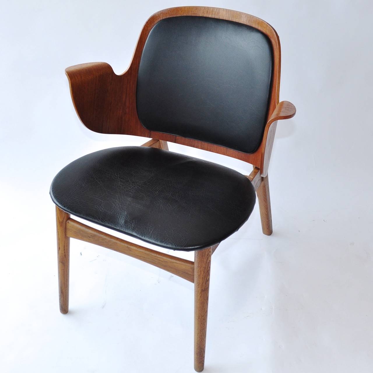 This extremely rare shell chair by Danish modern designer Hans Olsen for Bramin Mobler is made of bent plywood. The chair has two black leather pads.