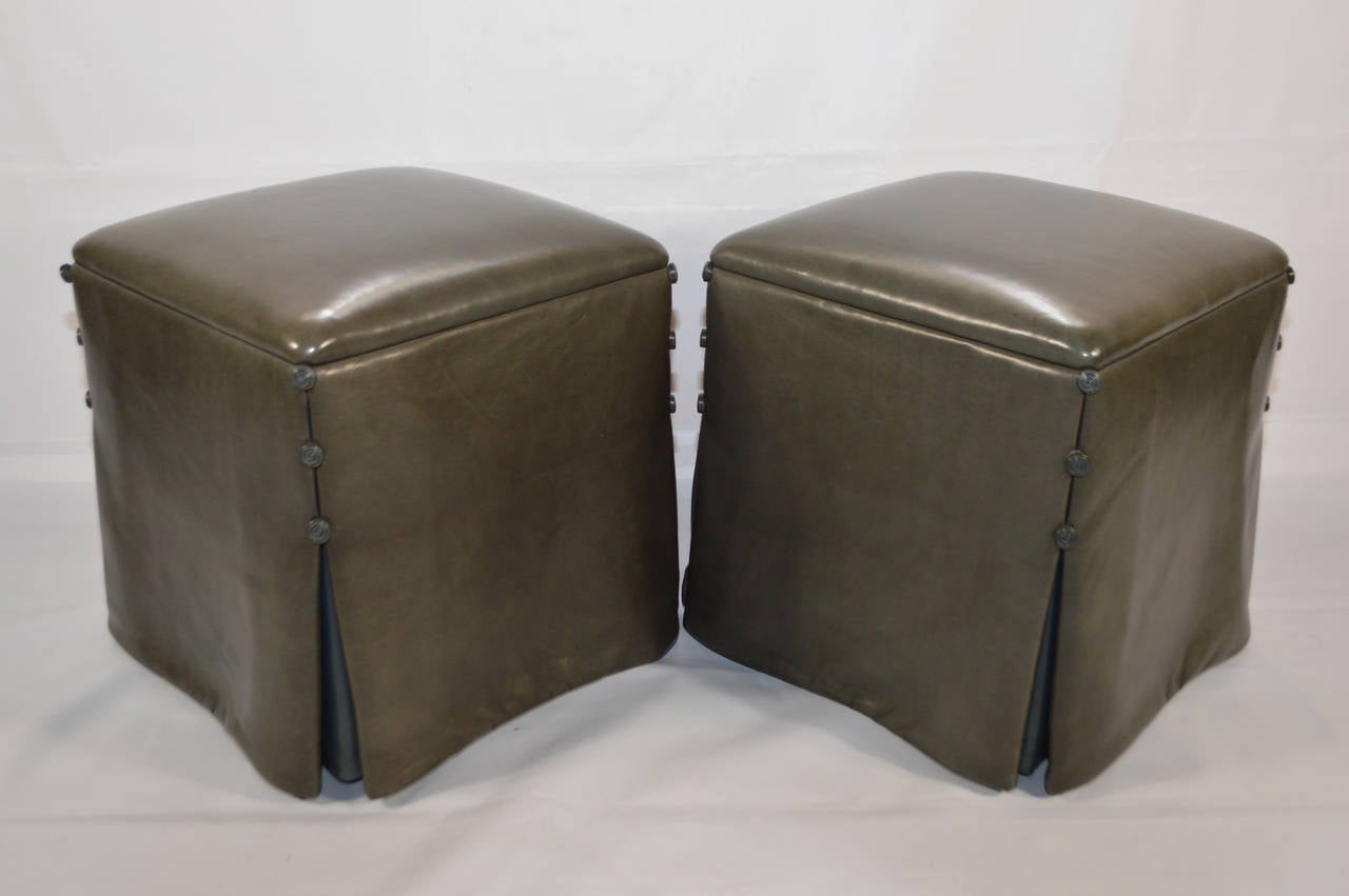 Restrained elegance and extraordinary quality in this pair of ottomans bathed in  luxurious kidskin with subtle button detail. 

Super kidskin (color: mole) with contrasting (color: blue) skirt insert

Snail knot detail at each corner