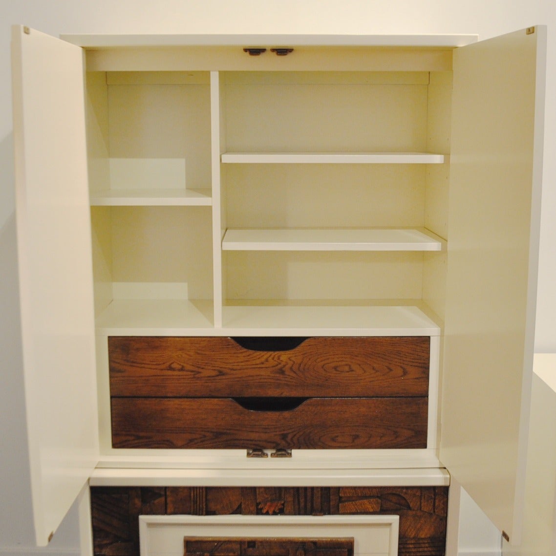 This striking brutalist armoire by Lane has been updated with a clear lacquer on its front panels and an off-white shade called Navajo Joe on its edges.
It features two large doors with 2 adjustable white lacquered shelves and 2 wood drawers inside