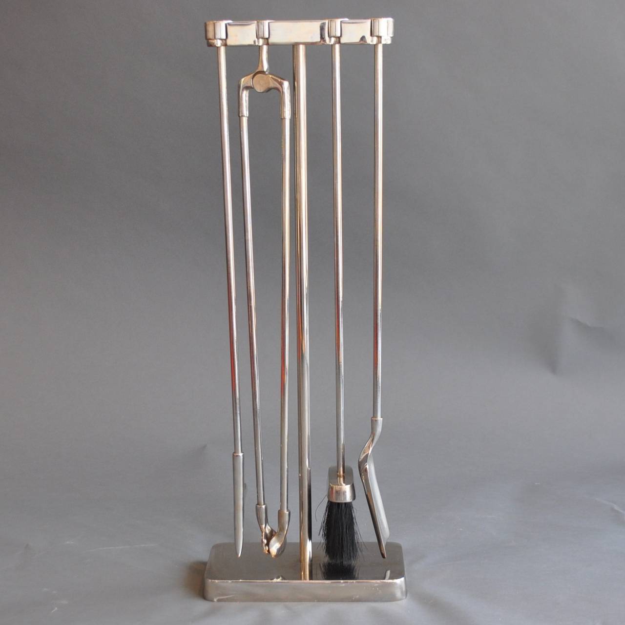 A vintage set of polished steel  fire tools on a 