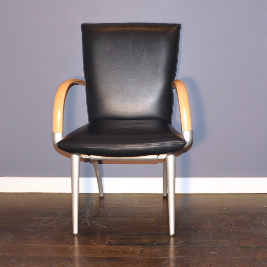 A set of four beautifully constructed black leather armchairs by Rolf Benz. The chairs are a fusion of great quality and excellent design. Each chair has a heavy anodized aluminum frame, bentwood arms, and leather seats. Any room that needs a touch