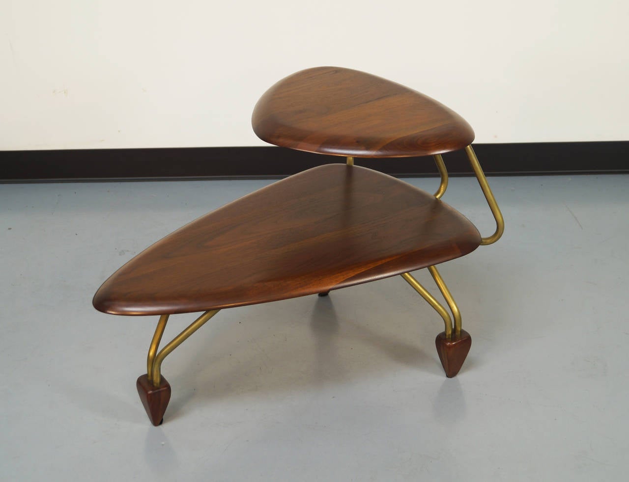 Rare side tables designed by John Keal for Brown & Saltman. Beautiful grain with body mounted on brass legs and anchored with wooden feet.

Matching coffee table also available.