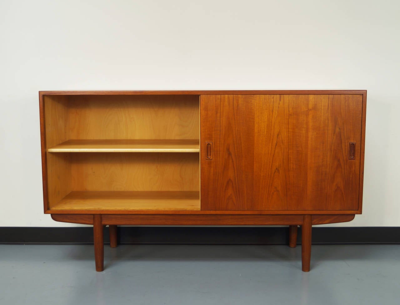 Danish teak credenza designed by Borge Mogensen. Features two large sliding doors which conceals an adjustable shelf and three drawers. Retains original label on the back.