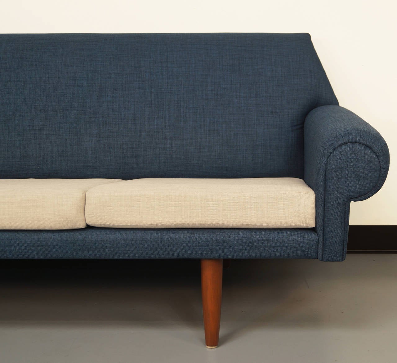 A elegant Danish sofa designed by Hans Wegner. Recently reupholstered in a two-tone linen fabric. Cushions contain original coil springs for superior comfort.