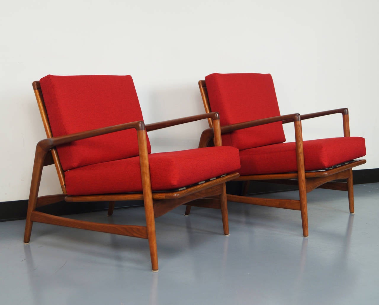 Pair of vintage Ib Kofod-Larsen reclining lounge chairs on sculpted oak frame. Chair have four reclining positions. It can either sit upright or can lock into its reclining positions.