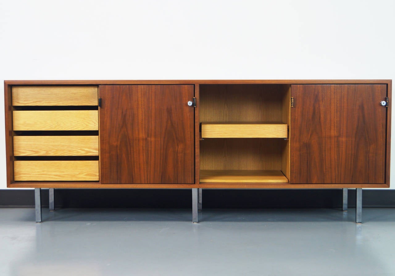 Vintage walnut credenza with original leather pulls by Florence Knoll for Knoll International. The interior consists of drawers, a file drawer, a pull-out shelf, and adjustable shelves. Key included.