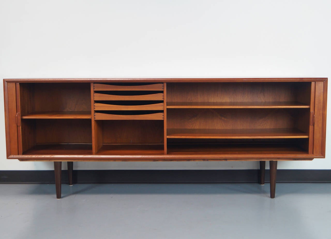 Danish tambour door credenza designed by Svend A. Larsen for Faarup Mobelfabrik. Interior has three adjustable shelves and four drawers. Finish teak back.