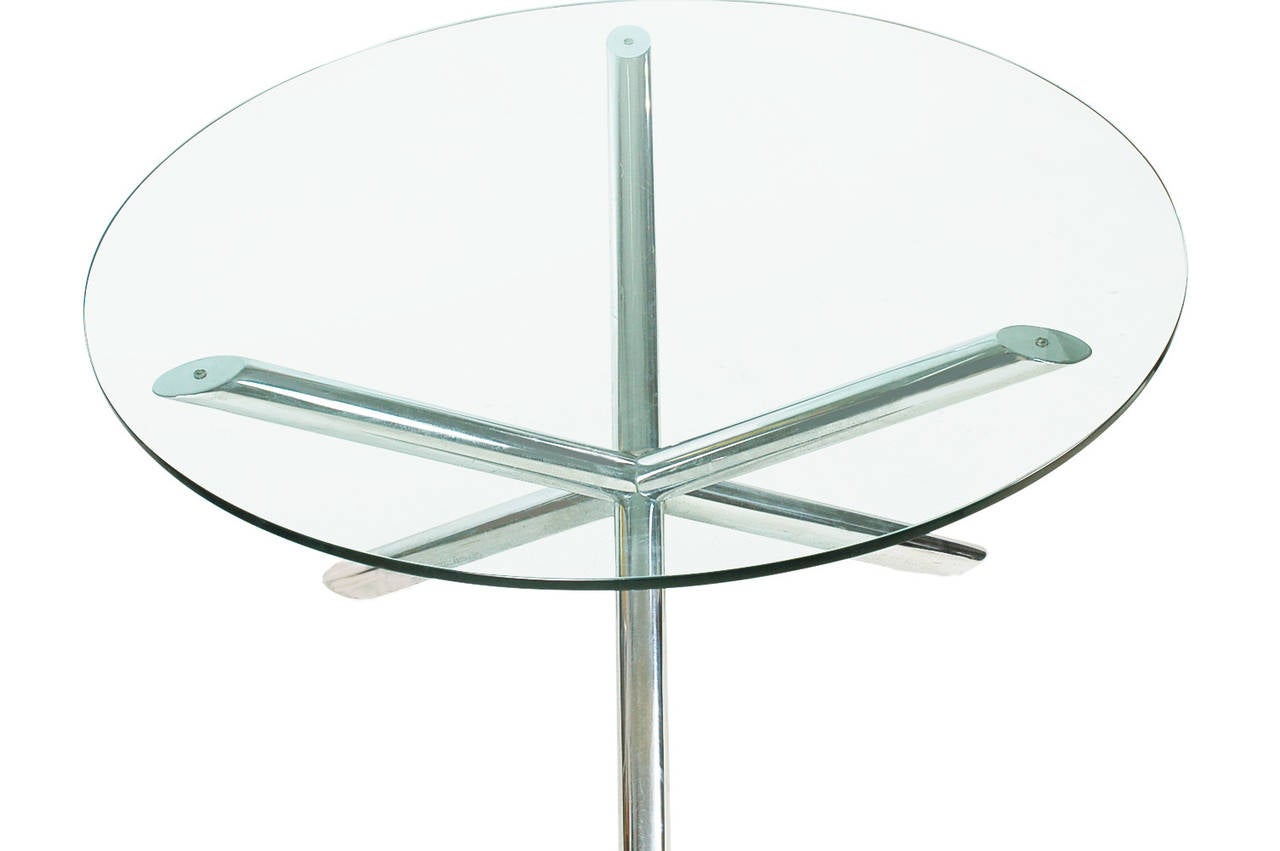 Une table de salle à manger élégante et raffinée avec un plateau en verre, à la manière de Milo Baughman. Il se compose d'une base tubulaire chromée et d'un plateau en verre épais.