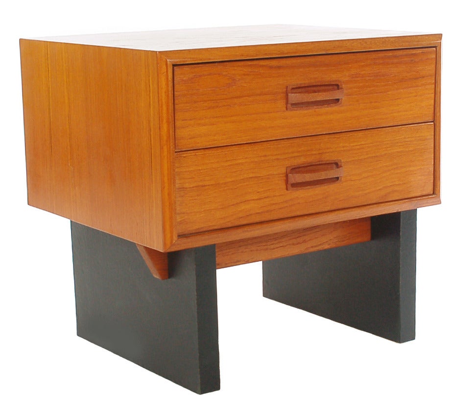 1970s very unique pair of Danish modern nightstands in teak. They feature a teak upper drawer cabinet on a chunky black laminate leg. These will add a funky twist to any Scandinavian bedroom design. They are both in very good condition showing some