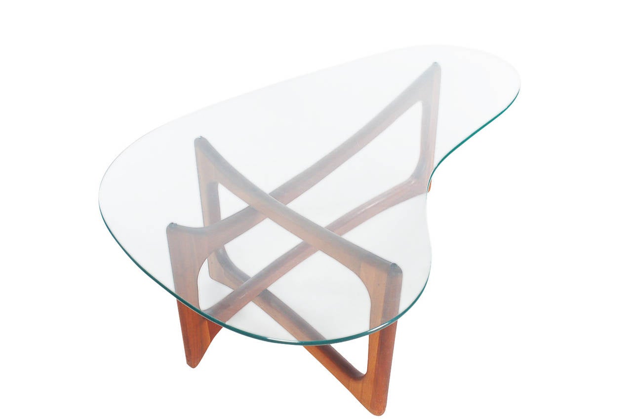 An iconic design cocktail table by Adrian Pearsall for Craft Associates. It features a masterfully sculpted interlocking walnut base with kidney shaped glass top. (unmarked)
