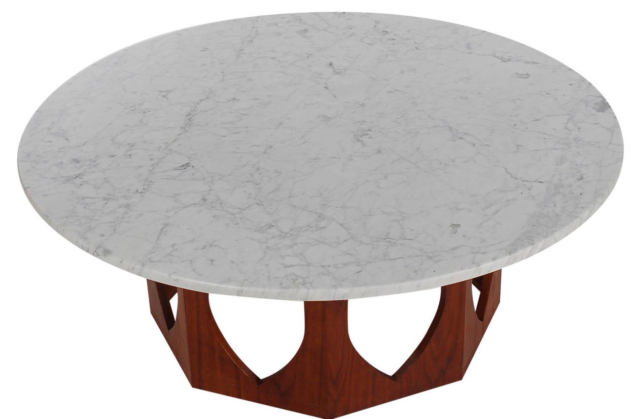 An iconic architectural designed coffee table attributed to Harvey Probber. It features a beautiful walnut base with heavy white/grey marble top.