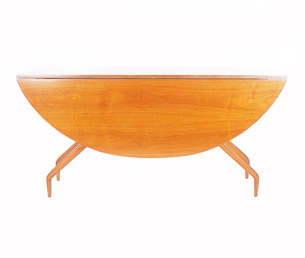 An incredible drop-leaf dining table designed by Greta Grossman and produced by Glenn of California. The walnut grain is as stunning as its design lines. In excellent original/unrestored condition. Closed measures: 18