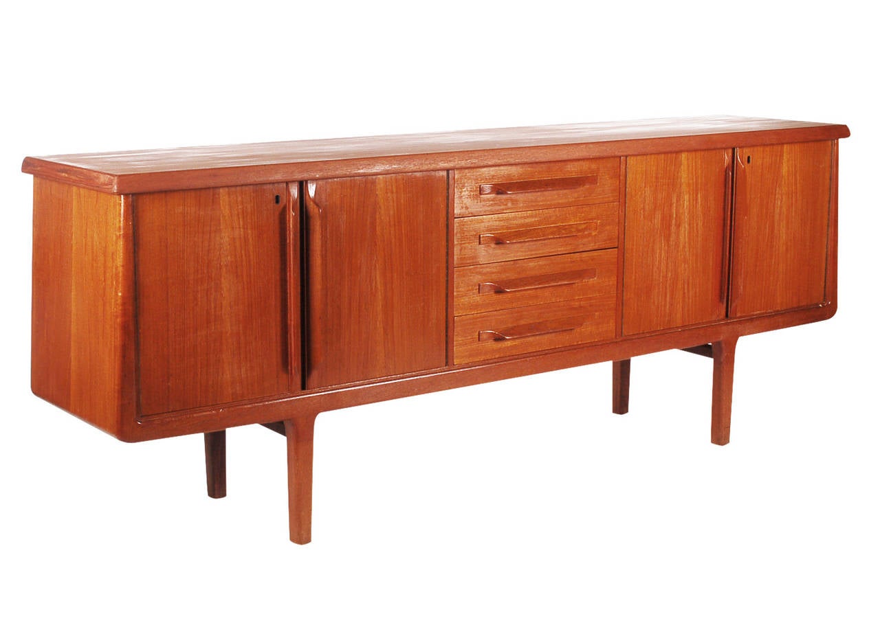 A beautifully designed teak credenza with top notch construction. It features two cubicles with shelves and four drawers. Marked Norway. Completely refinished condition.

In the style of: Kai Kristensen Arne Vodder