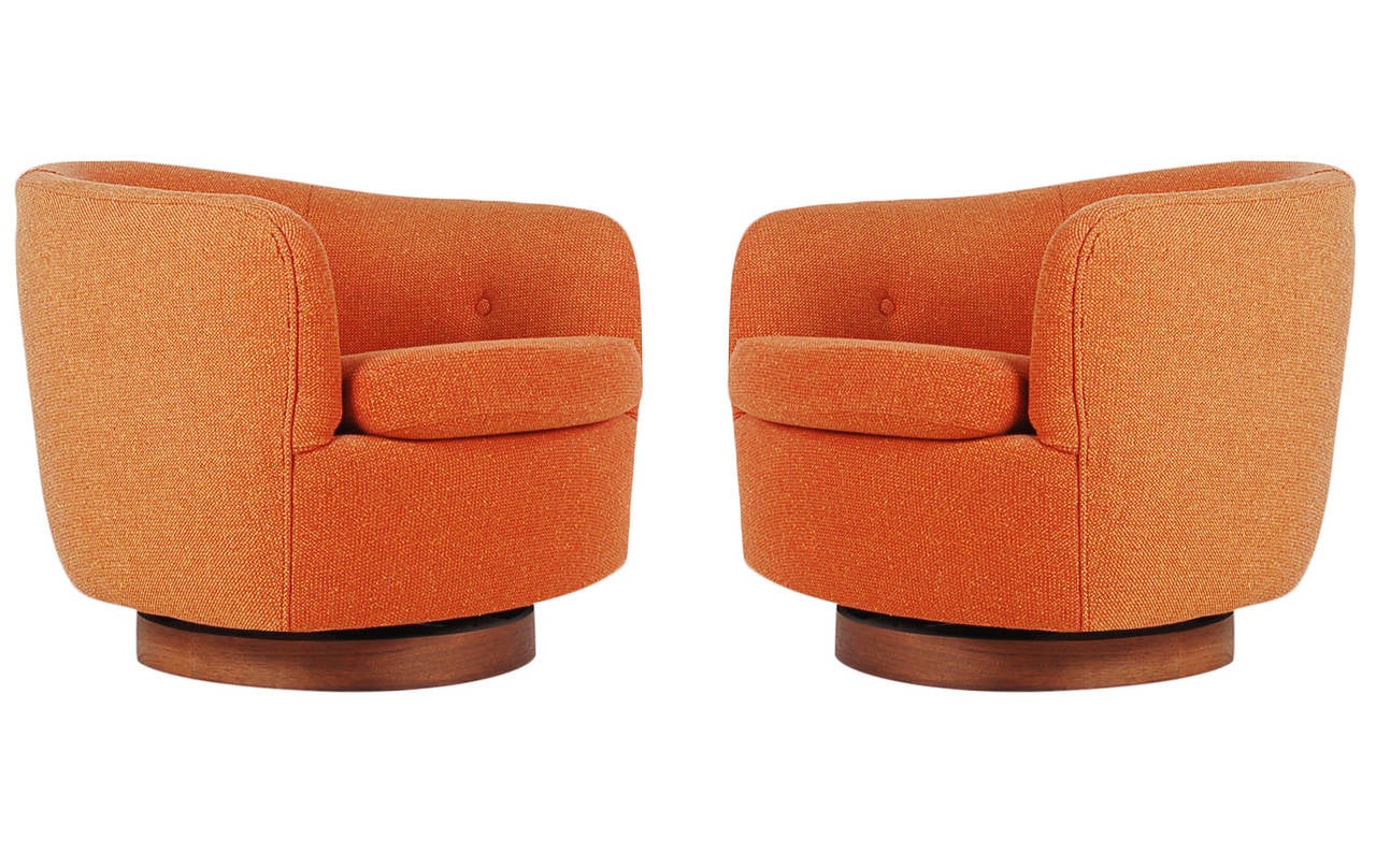 A handsome matching pair of club chairs designed by Milo Baughman for Thayer Coggin. They feature walnut swiveling platforms and burnt orange tweed upholstery. Manufacturers labels to both