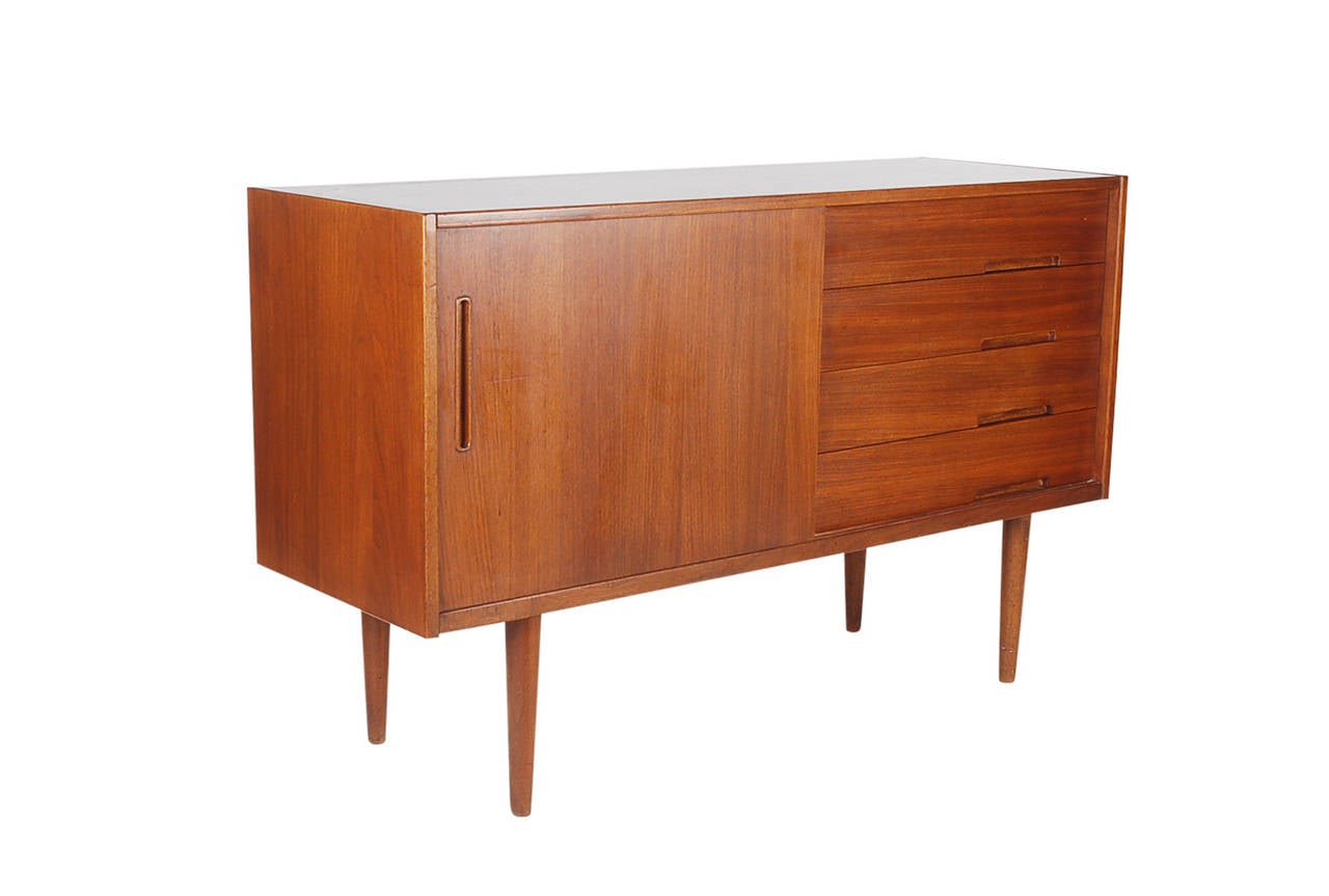 A nice scale sideboard perfect for the smaller space with plenty of storage. Teak construction, and designed by Nils Jonsson for Hugo Troeds in Denmark.