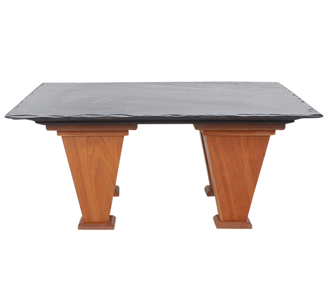 A custom-made studio cocktail slate top coffee table circa 1980s. It features natural cherry base with black slate top.