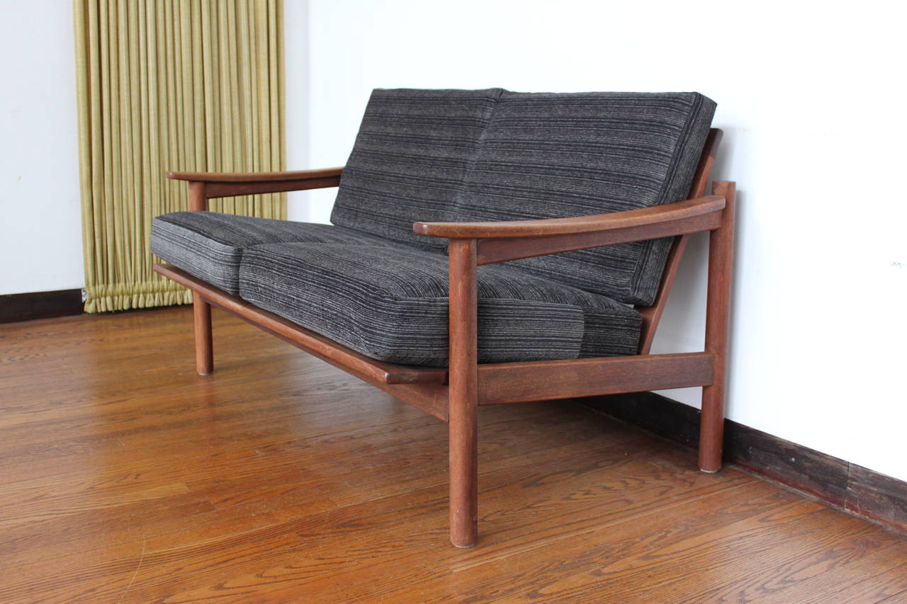 Lovely Danish teak sofa has new gun metal grey chenille striped upholstery and rubber wrapped coil springs.  Teak is warm and lovely.