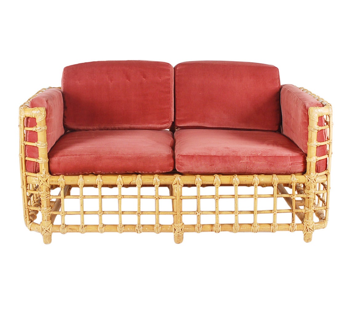 A very stylish two seat sofa in rattan. Very reminiscent of Franco Albini designs. Upholstery is in fair condition and can redone for $480 (buyer supplies fabric).