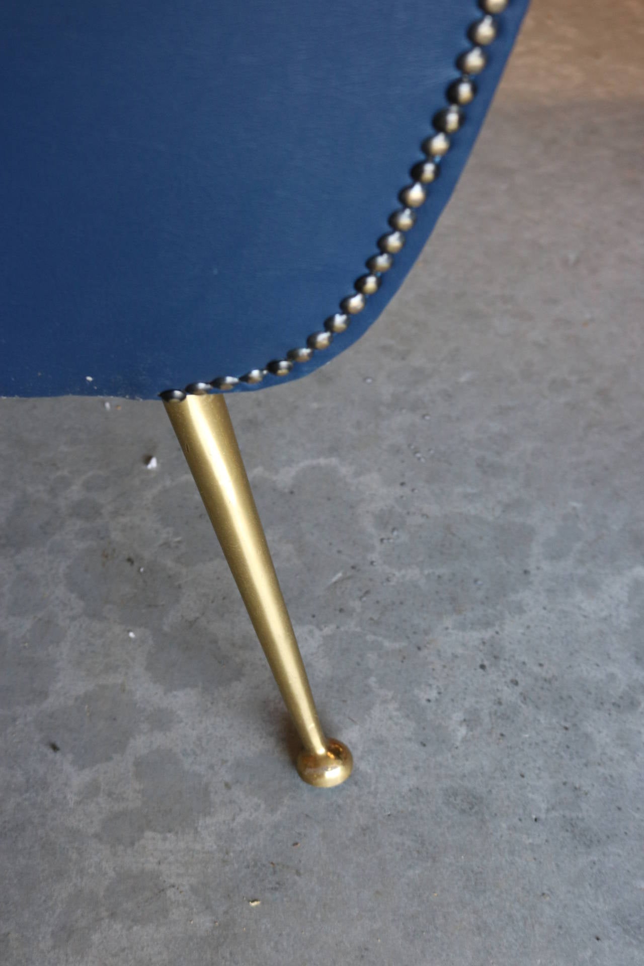 This is an exquisite pair of Mid-Century Modern armchairs made in Italy and designed by Gigi Radice. Each has been lovingly upholstered in blue Naugahyde with brass nails. Original sculptural brass legs are in excellent condition.
