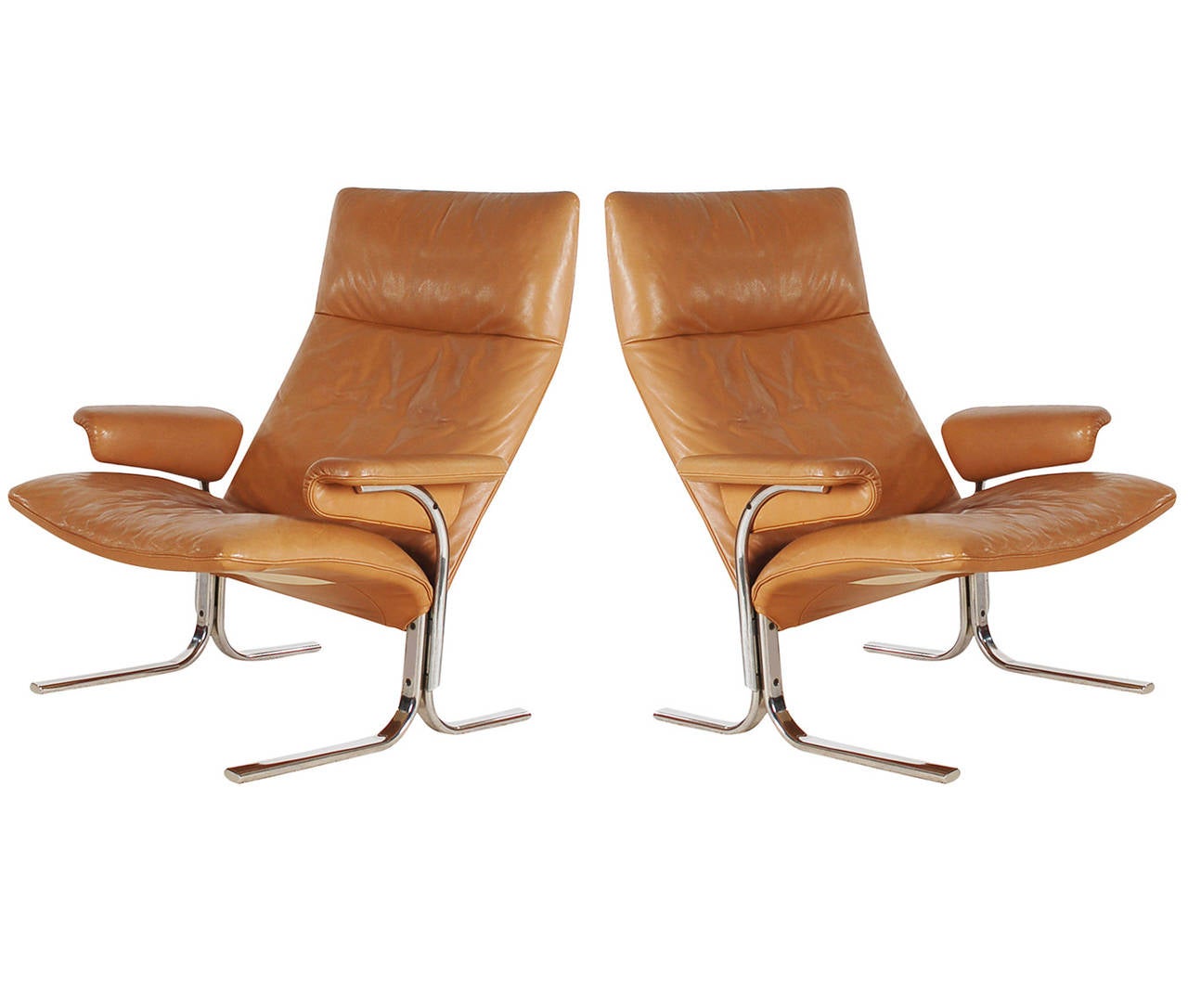 An incredibly stylish and comfortable pair of lounge chairs in tan leather. These were designed by Hans Eichenberger and produced by De Sede. These are extremely heavy and well made chairs from Switzerland. Manufacture labels to both.
