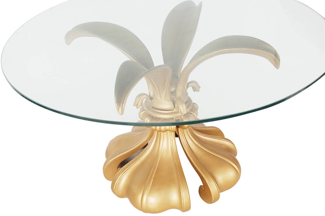 A heavy cast metal table, finished in a soft satin gold lacquer, and topped with heavy clear glass. A rich and sophisticated look, that can be used as a center or a low dining table. 

In the style of Arthur Court, Maison Jansen, Mastercraft.