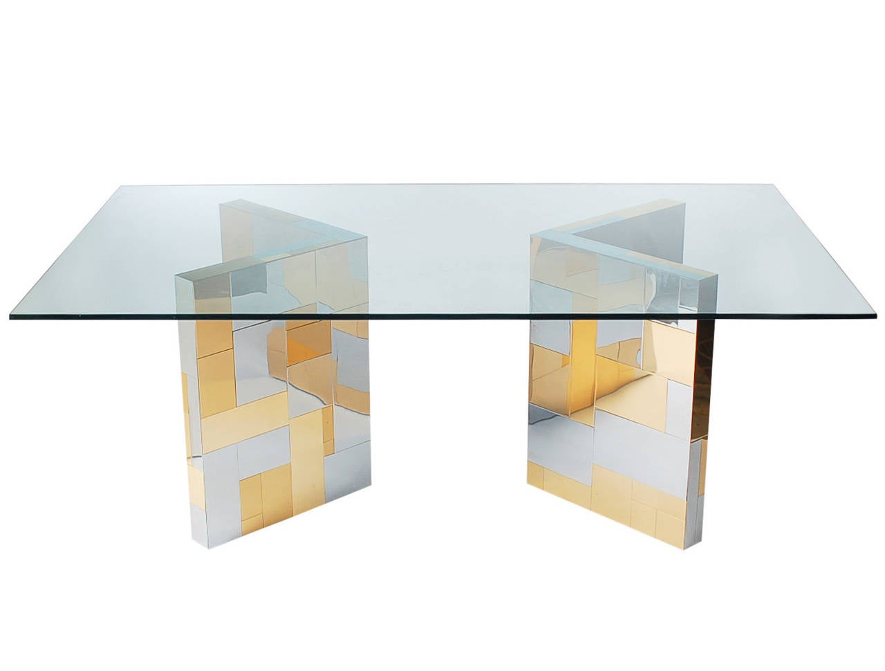 An exceptional patchwork designed dining table by Paul Evans. It consists of two L-shaped pedestals with nickel and brass plated panels, and a thick clear glass top. Pedestals can be configured in many different ways.