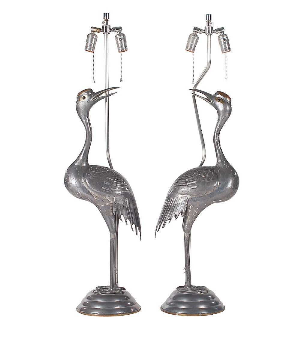 A highly decorative pair of bird form lamps in the Art Deco style and attributed to Sergio Bustamante. These are made to the highest of quality. All solid metal construction. Tested and working, each takes up to two 100 watt bulbs.